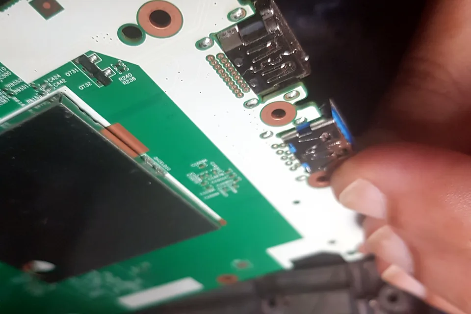 Game console motherboard being inspected during a repair assessment